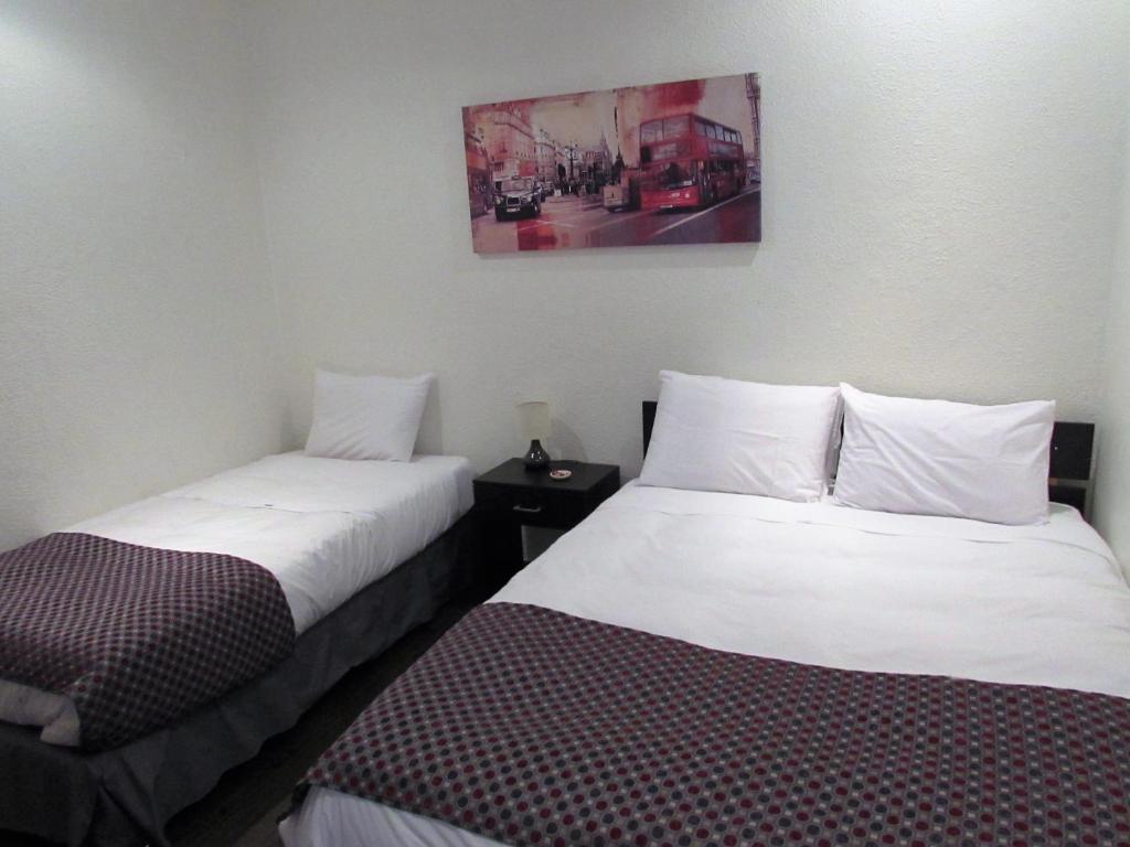 two beds sitting next to each other in a room at Hotel Central San Fernando in San Fernando