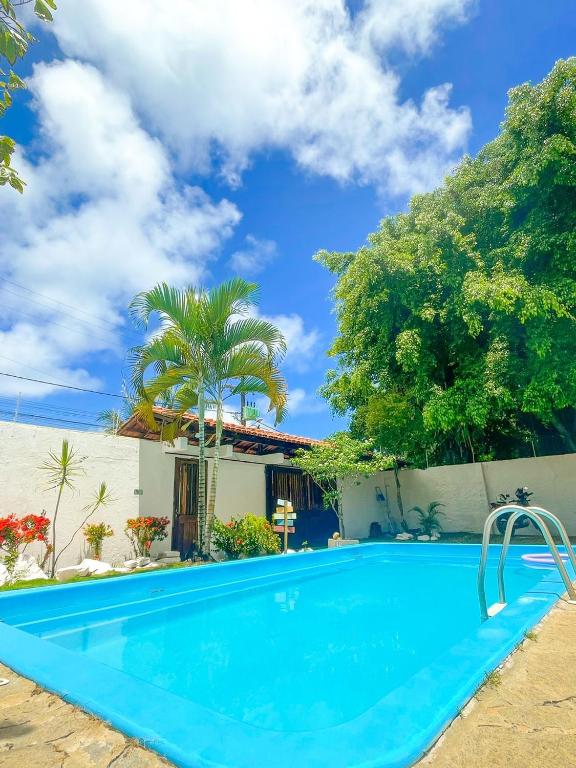a villa with a swimming pool in front of a house at Pousada Suítes do Atlântico in Ilhéus