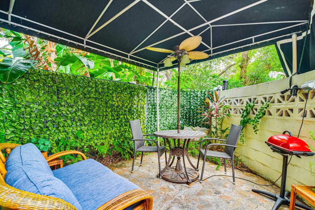 un patio avec une table, des chaises et un parasol dans l'établissement Peaceful Studio Near Golf Course in Clearwater!, à Clearwater