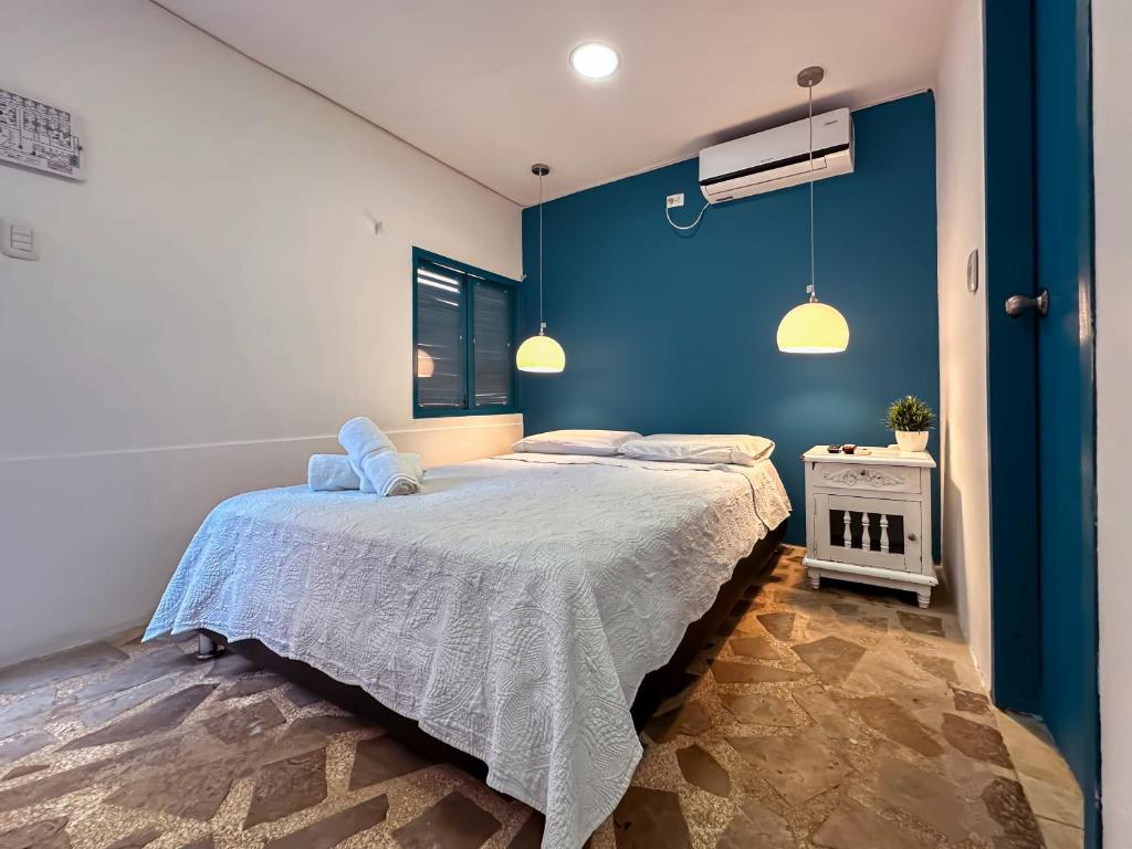 a bedroom with a large bed with a blue wall at Hotel Casamart Rodadero in Santa Marta
