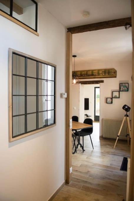 un salon avec une table et une fenêtre dans l'établissement La petite longère La mercerie, à Bourges