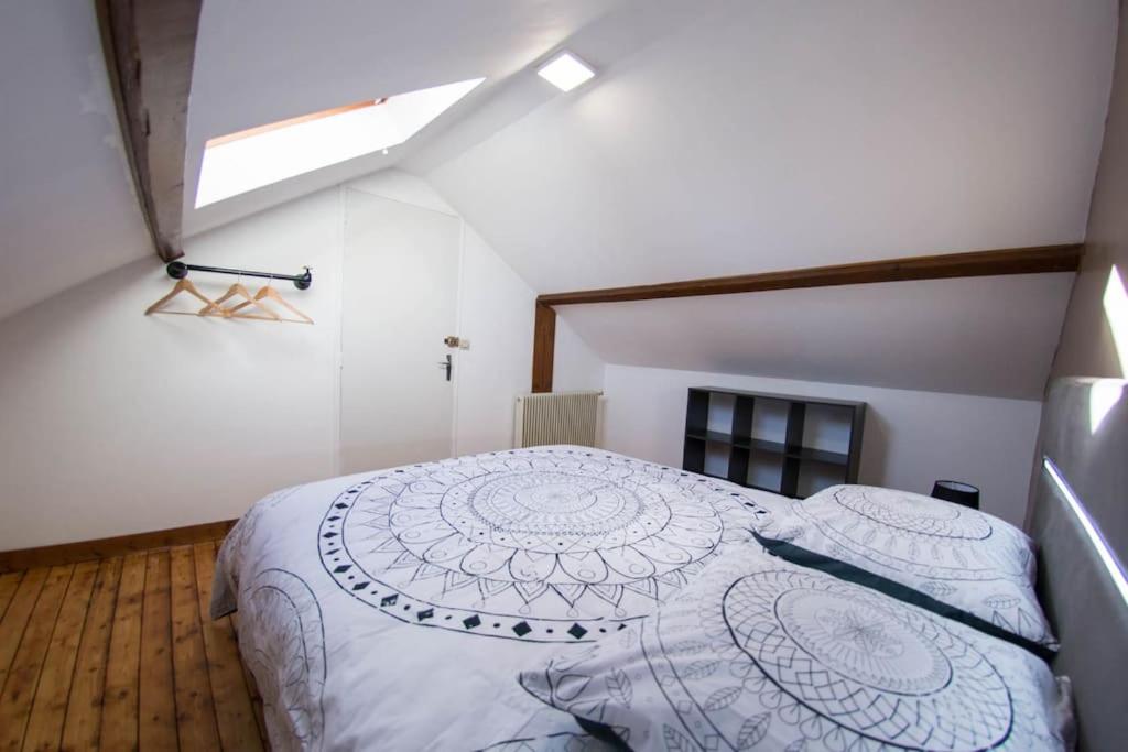 a bedroom with a white bed in a attic at La petite longère La mercerie in Bourges