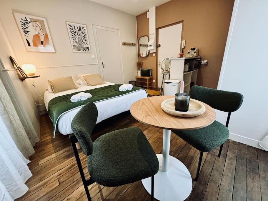 une chambre avec un lit, une table et des chaises dans l'établissement L'Oréva, adorable studio Rennes, à Rennes