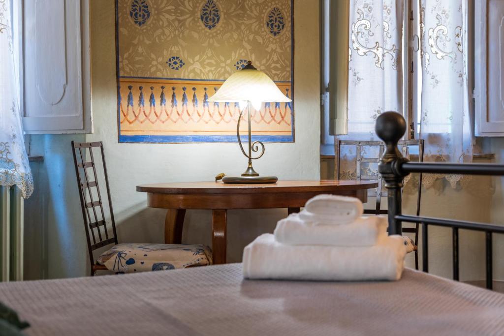 een tafel met een lamp en een tafel met een stoel bij Sweet Tuscany I Due Gigli in Arezzo