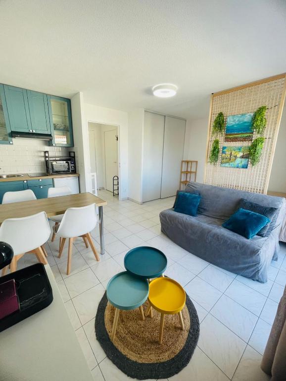 un salon avec un canapé, une table et des chaises dans l'établissement Studio climatisé - Port Fréjus, plage à 250m, à Fréjus