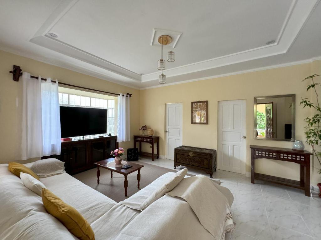 Una sala de estar con un sofá y un televisor. en Cajigal Farmhouse - high speed converge internet and AC in 2 bedrooms, en Badoc