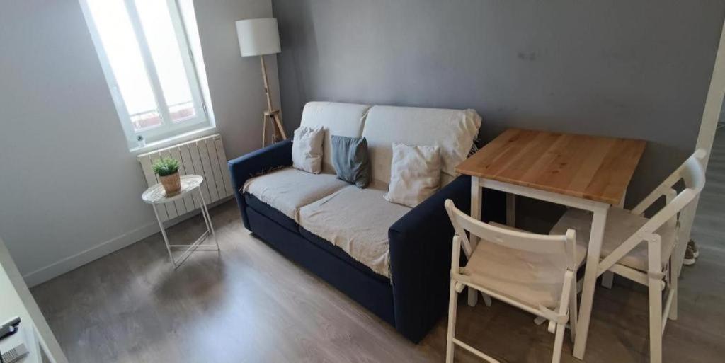 un salon avec un canapé bleu et une table dans l'établissement Home Sweet Home, à Aubervilliers