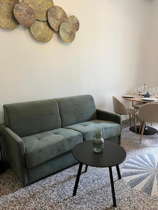 un salon avec un canapé vert et une table dans l'établissement Le cosy de la cité Foulc, à Nîmes