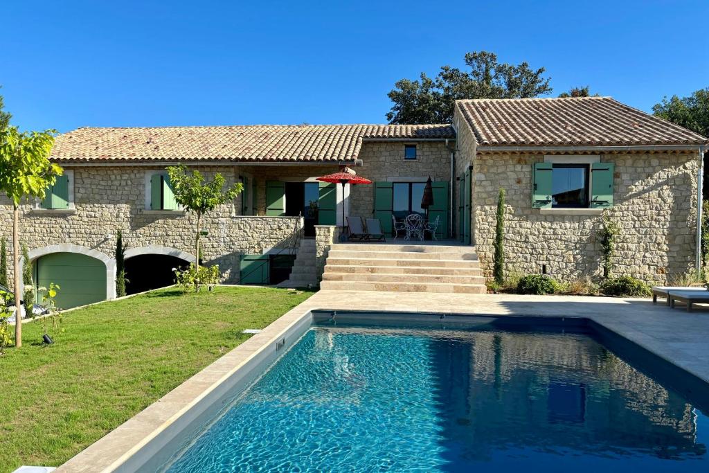 a house with a swimming pool in front of a house at LE Mas Jas magnificent Mas Provençal - Lauris in Lauris