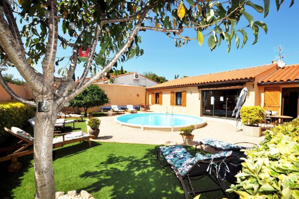 une cour avec une piscine et une maison dans l'établissement Proche Château de Salses, Maison avec piscine, à Salses-le-Chateau