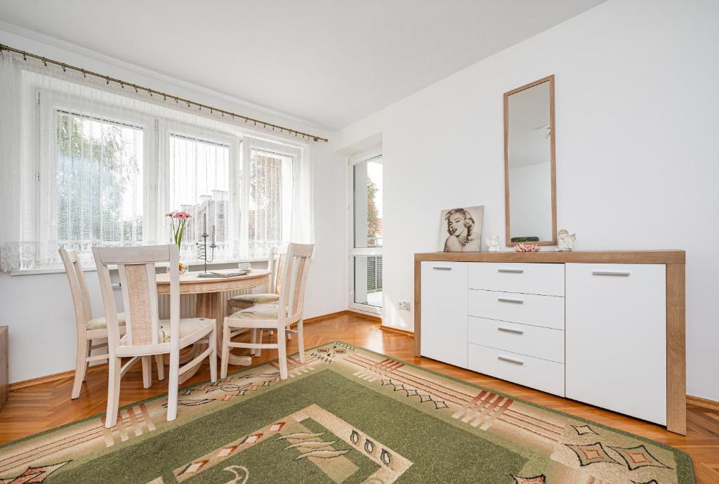 a dining room with a table and a mirror at Apartament Emily Brzeźno in Zaspa