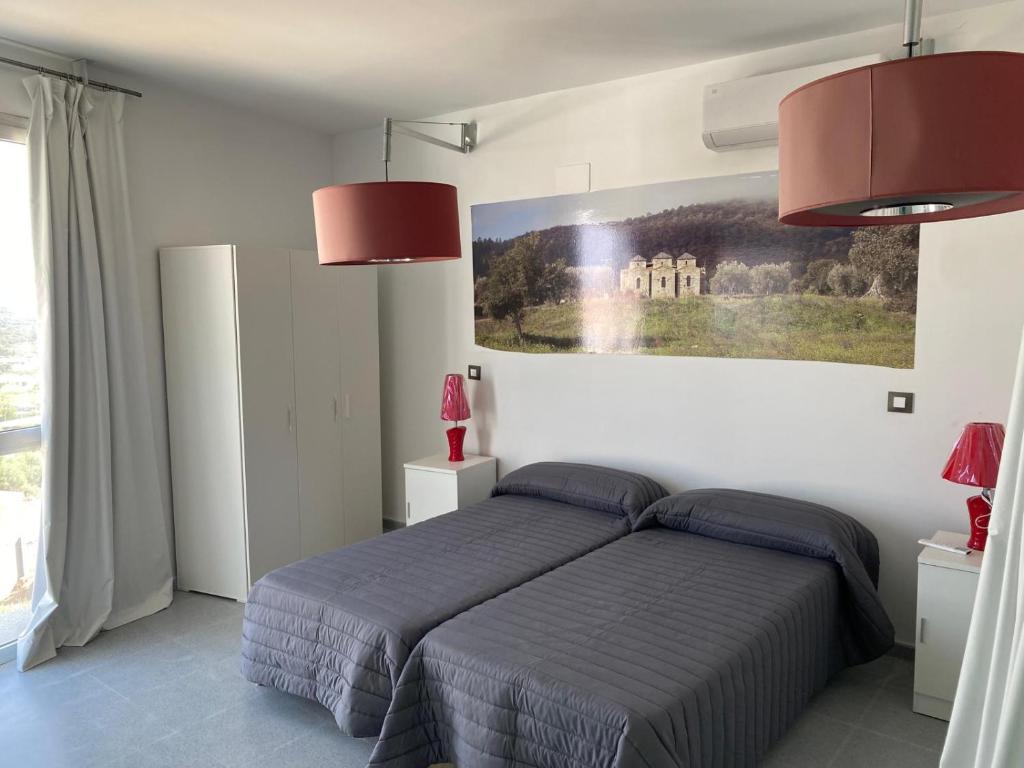 AlcuéscarにあるAlbergue turistico Alcuescar vía de la plataのベッドルーム1室(ベッド1台、ランプ2つ、絵画付)