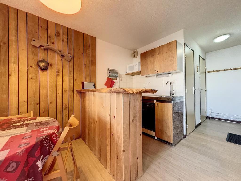 - une cuisine avec des murs en bois, une table et un comptoir dans l'établissement Studio Samoëns 1600, à Samoëns
