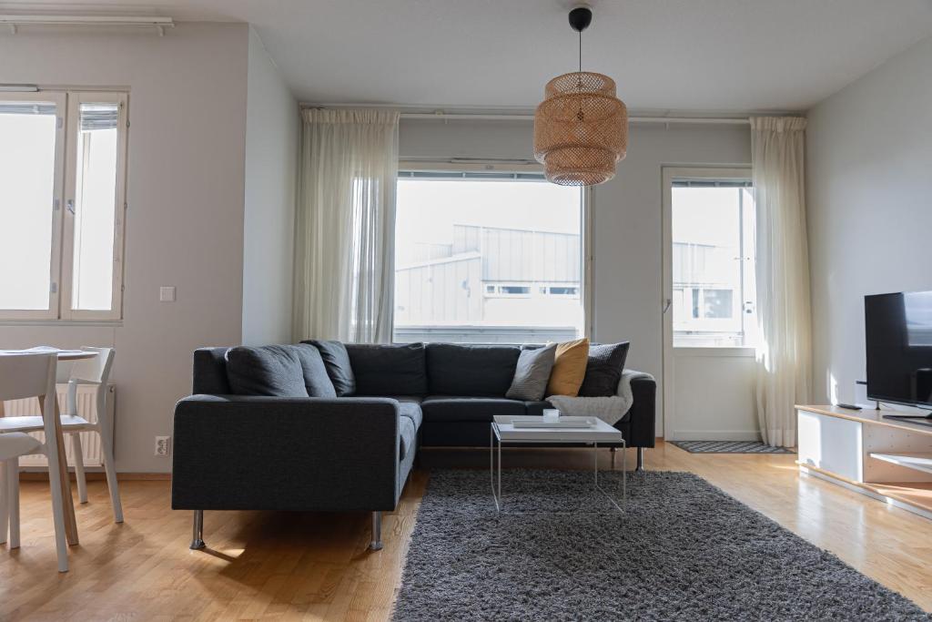 Una sala de estar con un sofá y un televisor. en Riverside Suites by BookLapland, en Rovaniemi