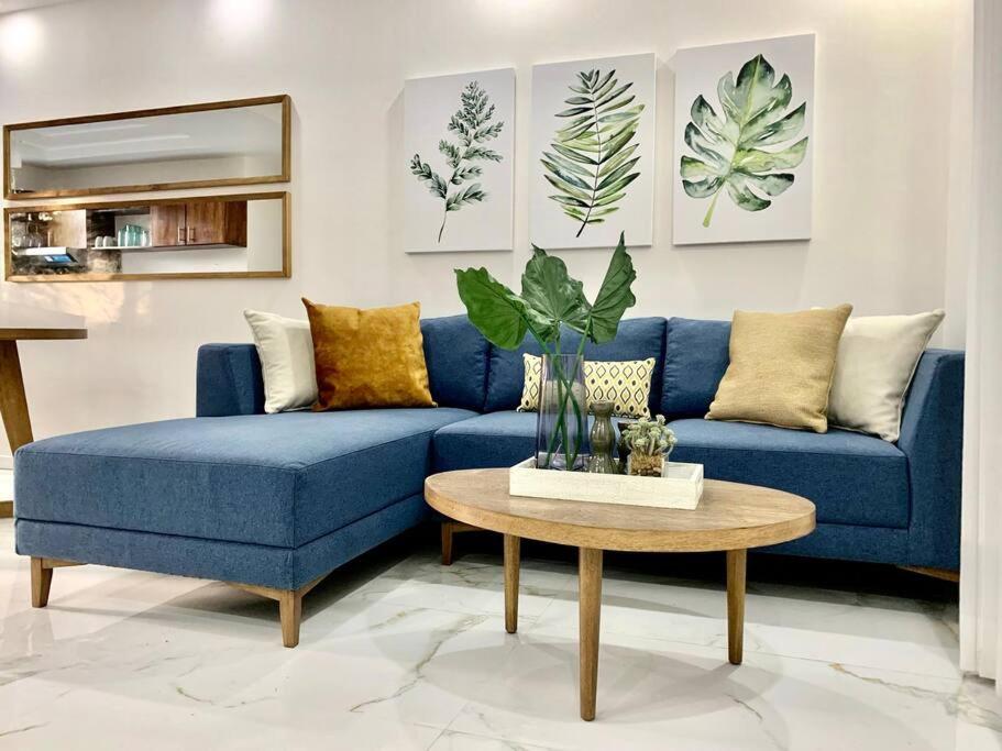 塔马林多Gav10 Modern Pool Side Condo in Quiet Area of Tam的客厅里的一张蓝色沙发和一张桌子