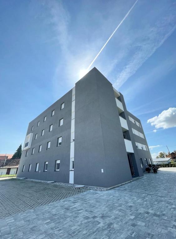 a large building with the sun behind it at Apartman Danijela in Popovača