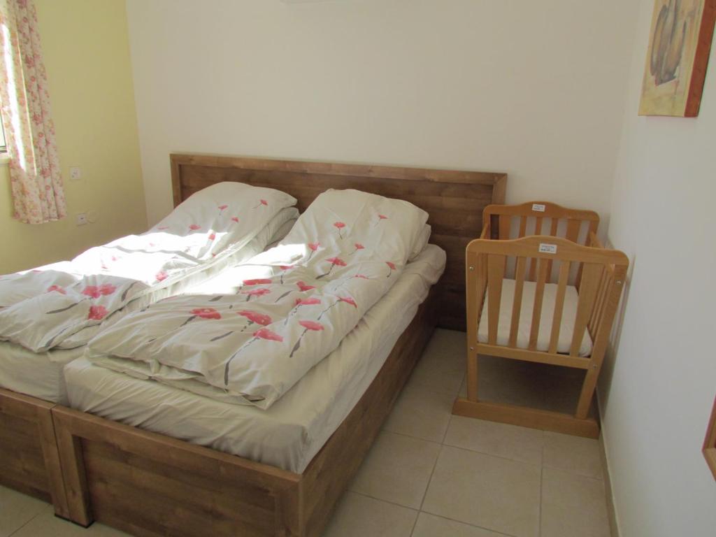 a bedroom with a bed and a wooden crib at Family Zimmer in Hosha‘ya