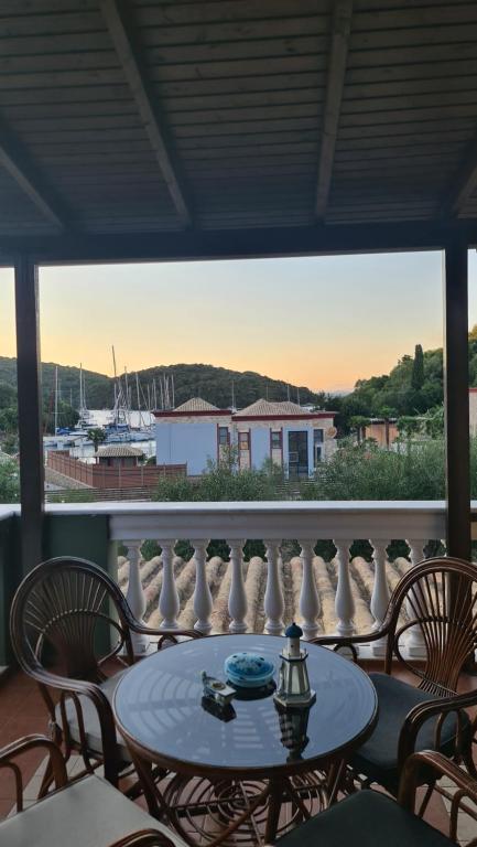 a table and chairs on a balcony with a view of a boat at Edem Studios in Syvota