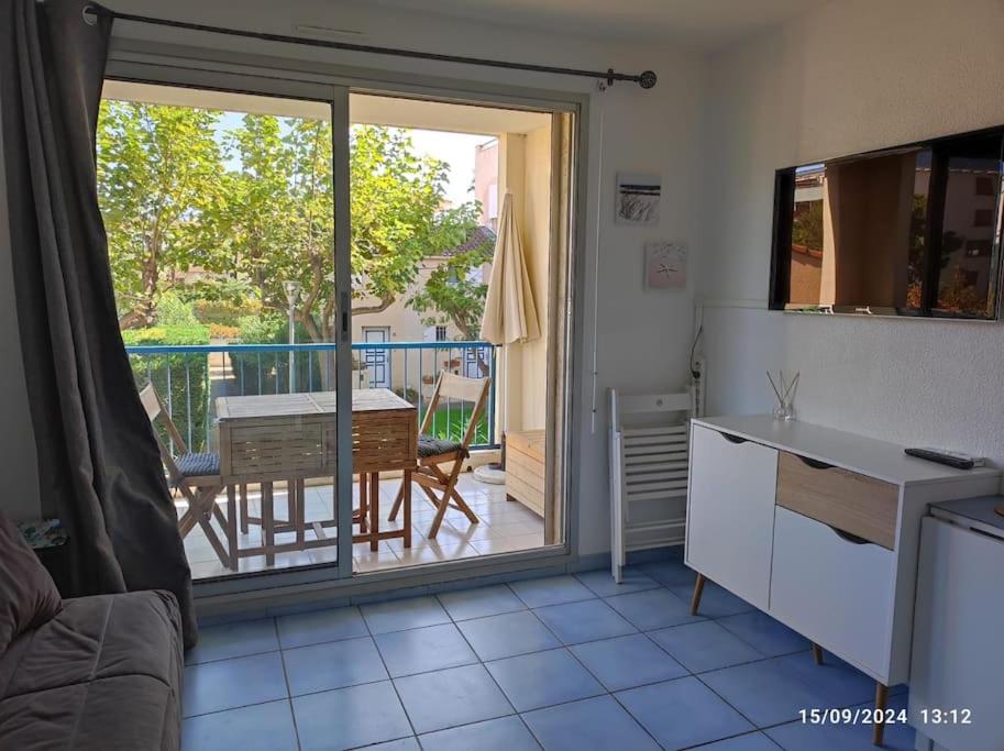 une cuisine avec vue sur une table et un balcon dans l'établissement Studio cabine tout équipé, au Lavandou