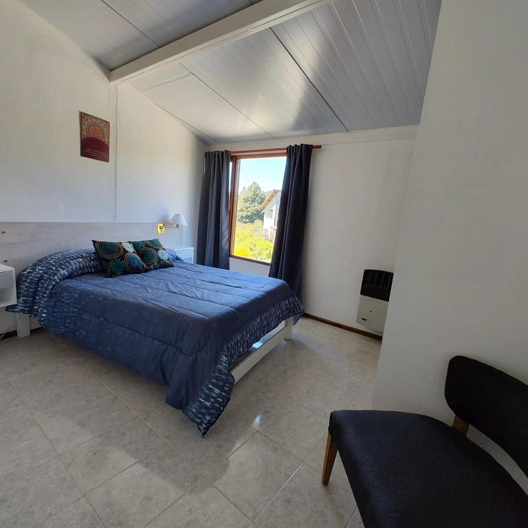 a bedroom with a large bed with a window at Sol de montaña, Bariloche. in San Carlos de Bariloche