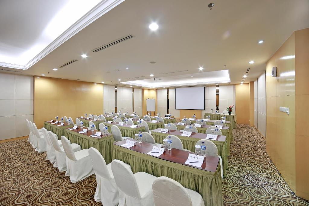 una stanza con file di tavoli e sedie bianche di All Sedayu Hotel Kelapa Gading a Giacarta