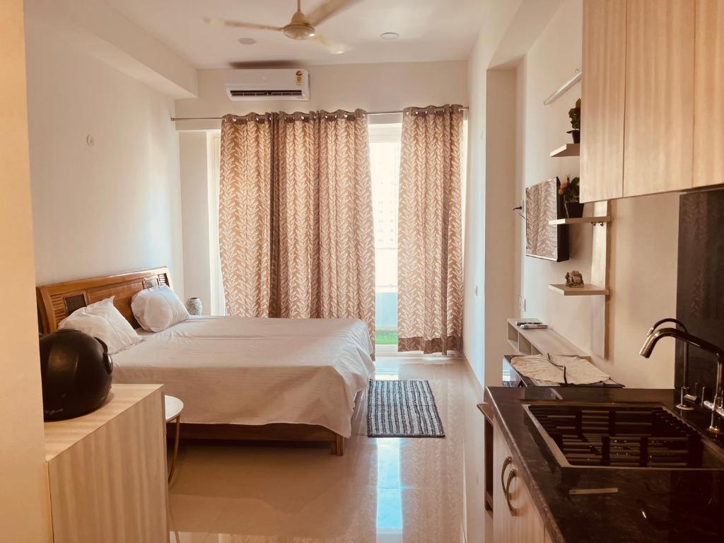 a small bedroom with a bed and a window at Royal orbit studio in Ghaziabad