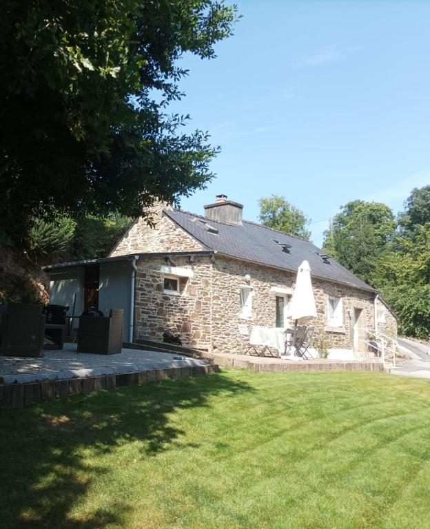 une ancienne maison en pierre avec une cour herbeuse dans l'établissement La pierre du bois, à Kergloff