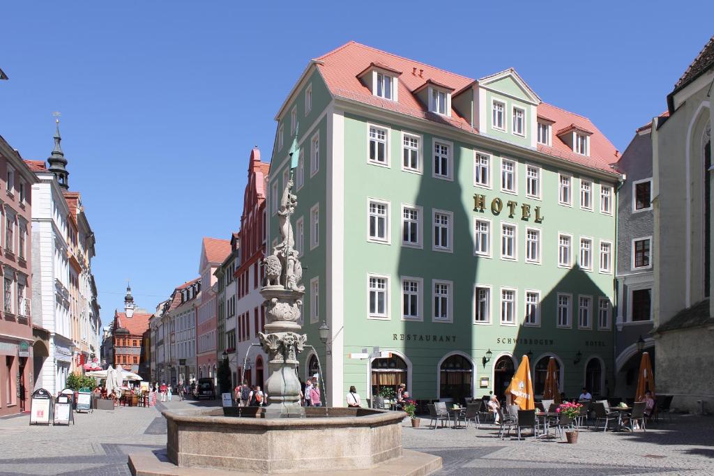 a building with a fountain in the middle of a street at Hotel Schwibbogen Görlitz in Görlitz