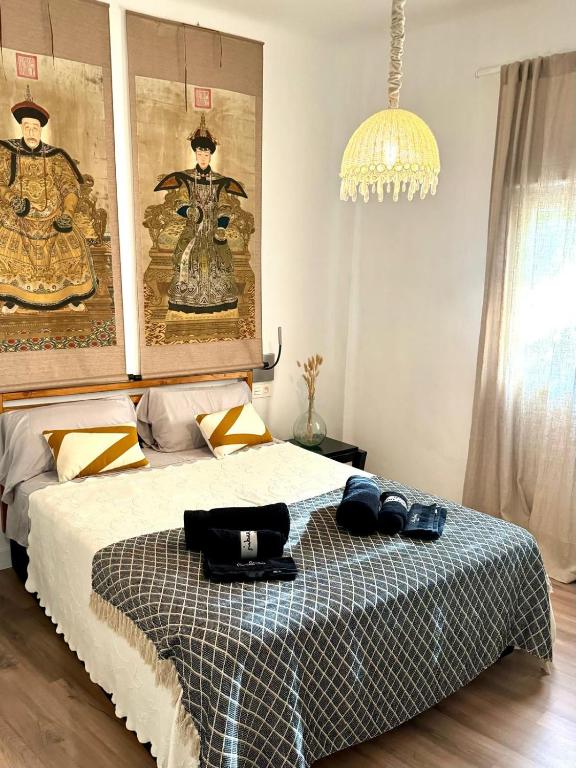 a bedroom with a bed and a chandelier at Apartamento con Parking El Rincón del Arte Granada Centro in Granada