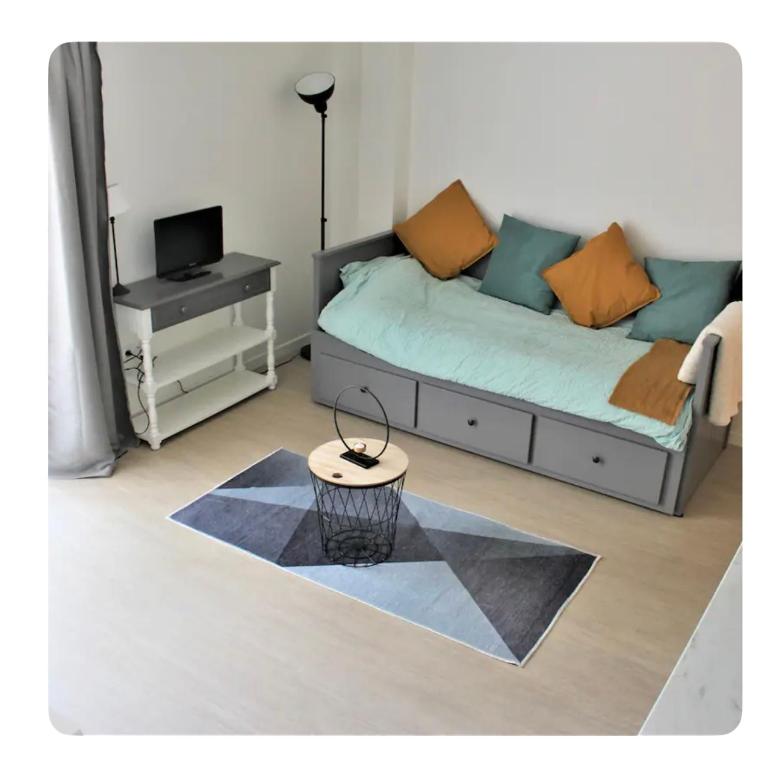 une chambre avec un lit et une table avec une télévision dans l'établissement Studio 18, au Havre