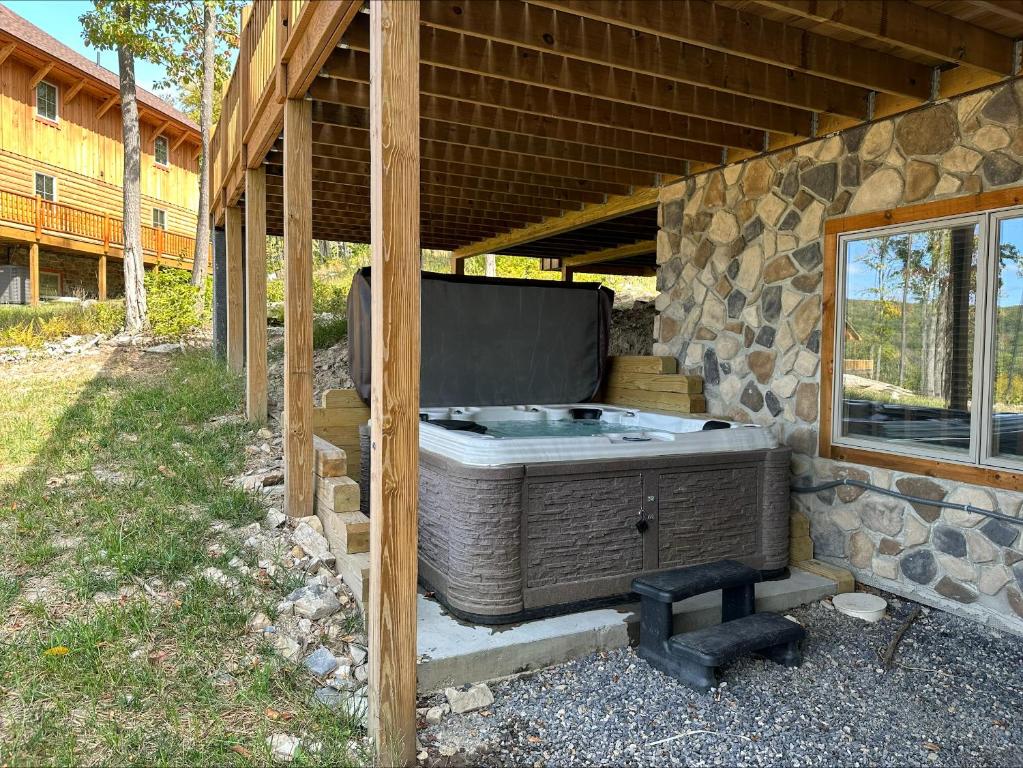 a hot tub sitting under a stone building at Fortune Mountain Retreat in McHenry