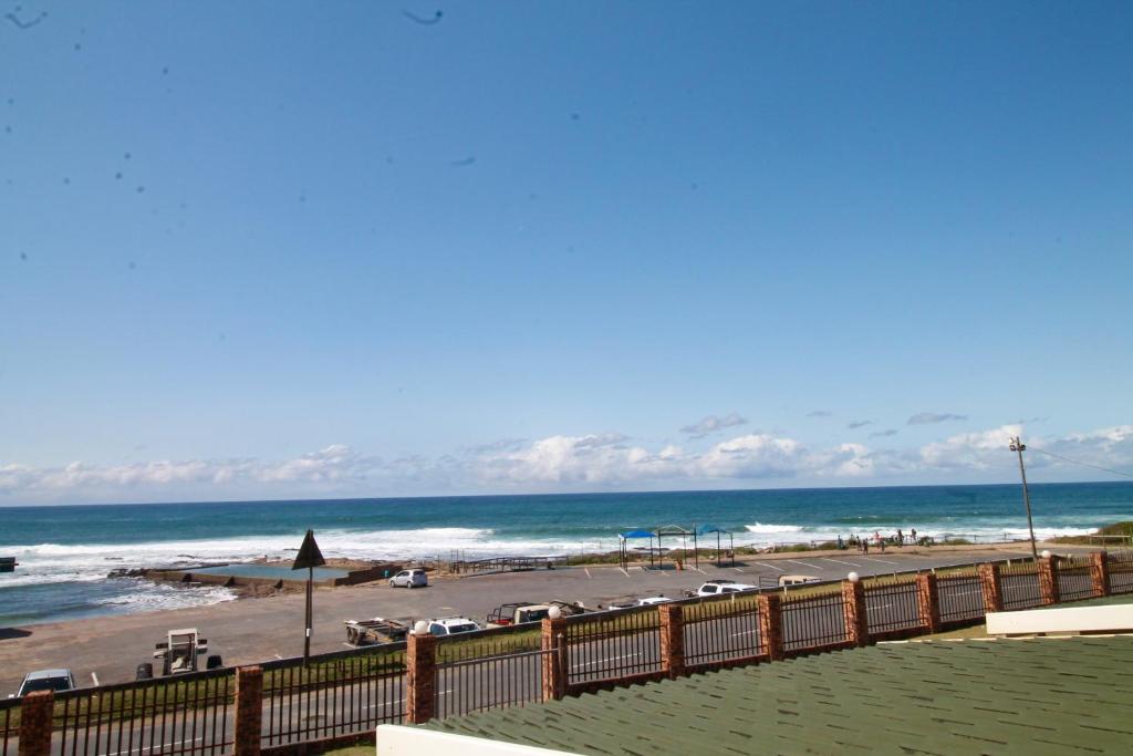a view of a beach with a fence and the ocean at Eden Dunes 68 in Shelly Beach