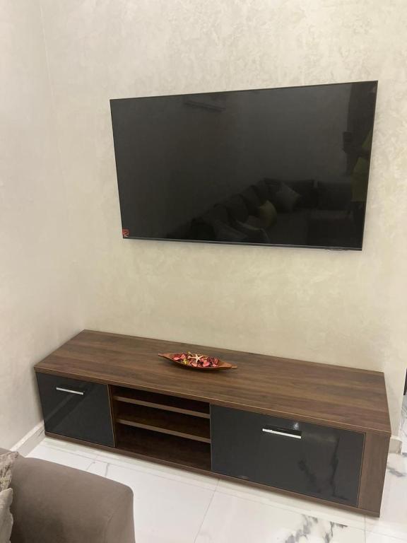 a flat screen tv on a wall with a table at Appartement la Cañada in Ville Nouvelle