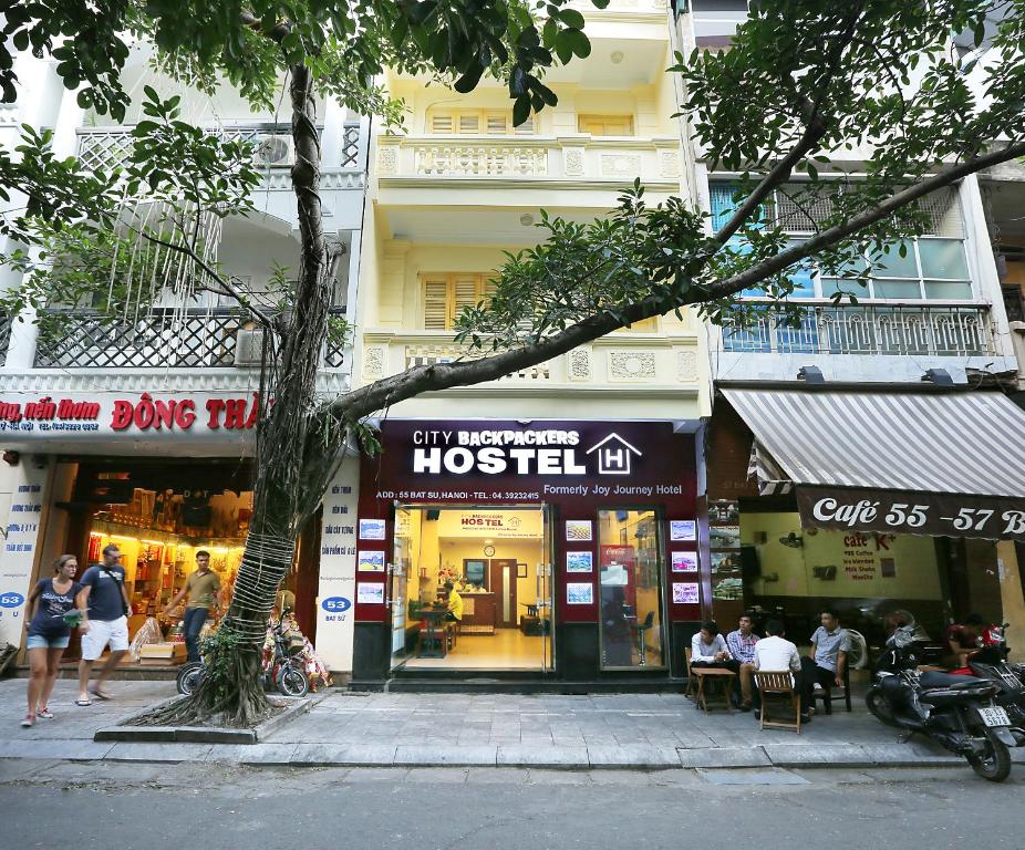 a street with people walking in front of a hostel at Hanoi City Backpackers Hostel in Hanoi