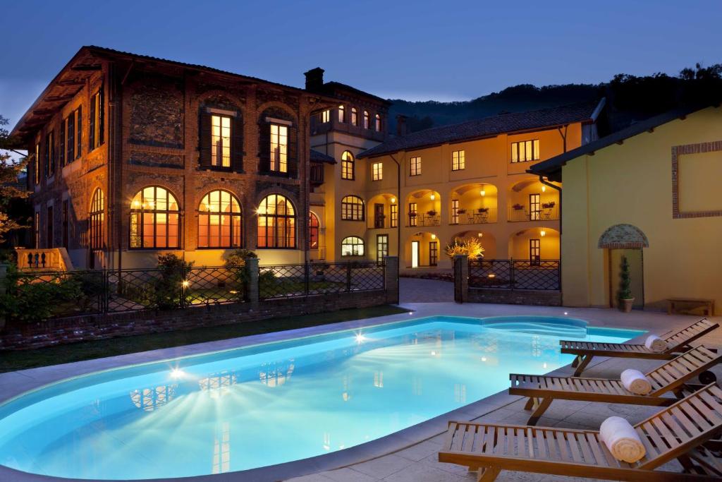 a large swimming pool in front of a building at Villa Soleil in Colleretto Giacosa