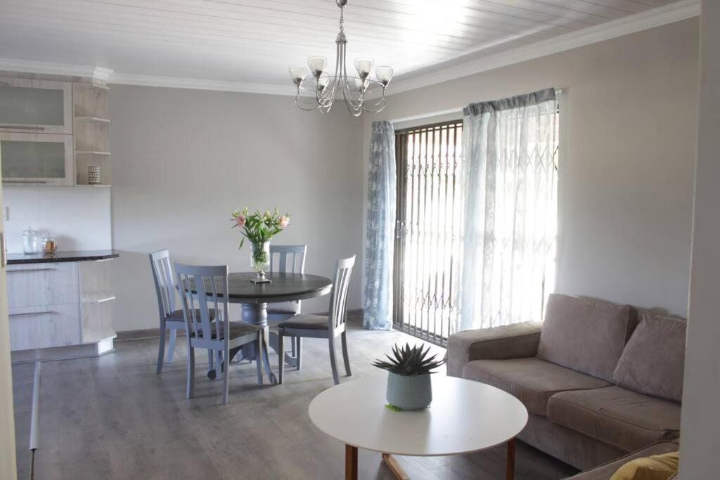 a living room with a couch and a table at Hidden Gem in Bloemfontein