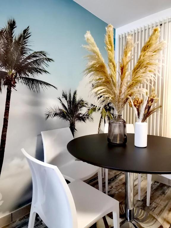 - une salle à manger avec une table et des palmiers dans l'établissement Proche de Nancy centre, appart cinéma rénové avec parking gratuit, à Nancy