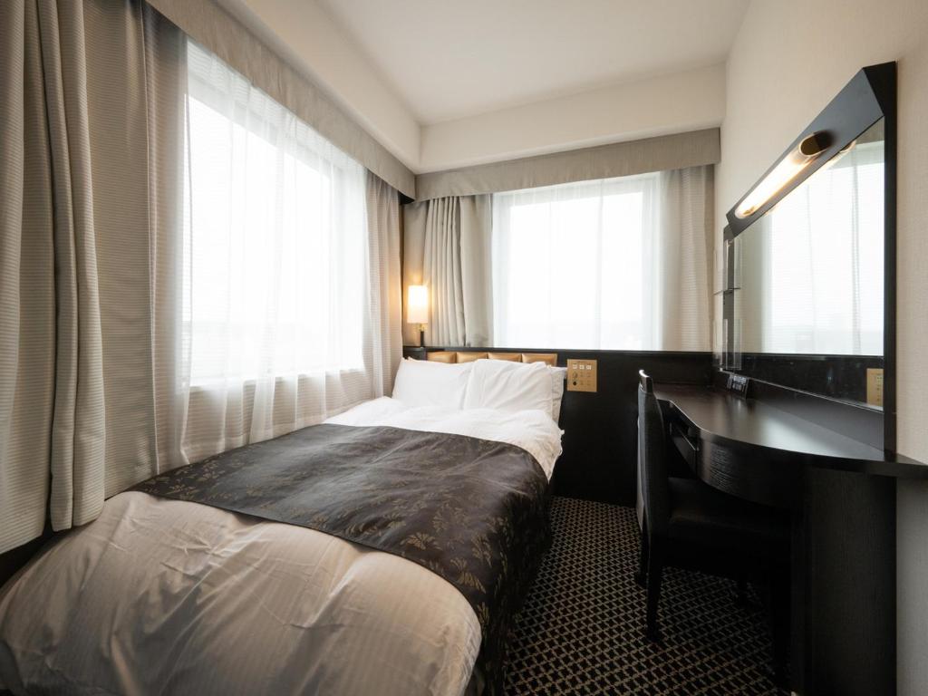 Postel nebo postele na pokoji v ubytování APA Hotel Fukui Katamachi