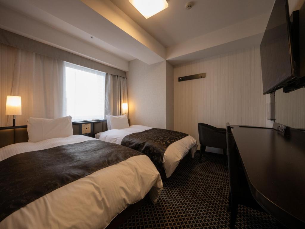 Postel nebo postele na pokoji v ubytování APA Hotel Fukui Katamachi