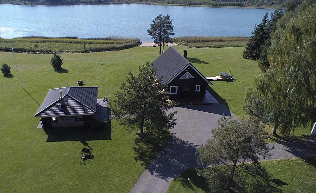 an aerial view of a house in a field next to a lake at Mäeküla Järve Palkmaja in Viljandi