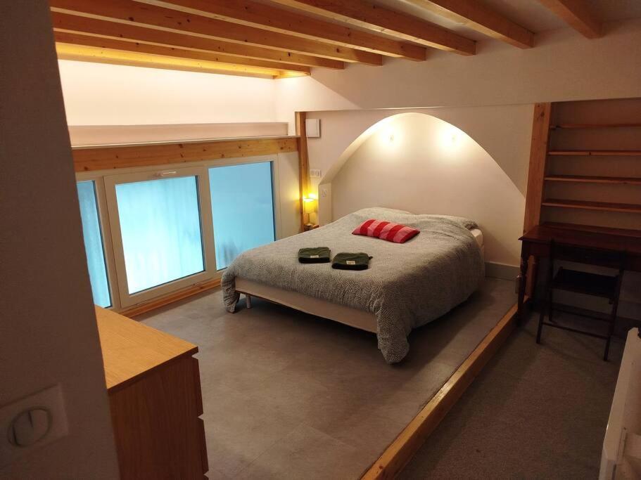 - une chambre avec un lit doté d'oreillers rouges dans l'établissement Le Coq Bleu, à Reims