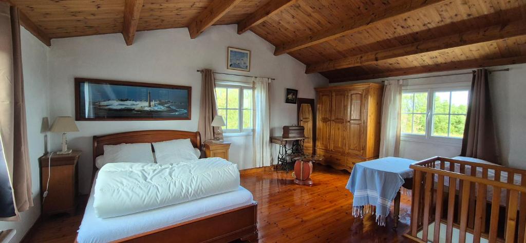 une chambre avec un lit dans une pièce avec des plafonds en bois dans l'établissement Maison de famille bord de mer, à Ker Pierre Borny