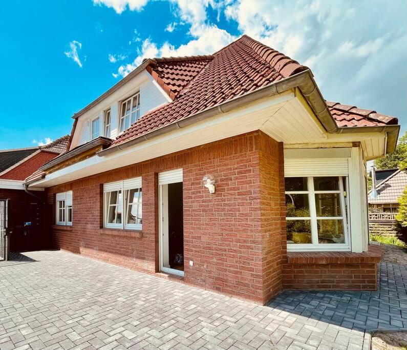 a red brick house with a brick driveway at Ferienhaus Butjadingen - Haus Ruhwarden in Ruhwarden