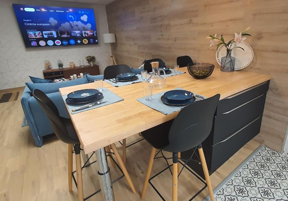 une table à manger avec des chaises et une télévision dans l'établissement Appartement cosy & fonctionnel !, à Lempdes