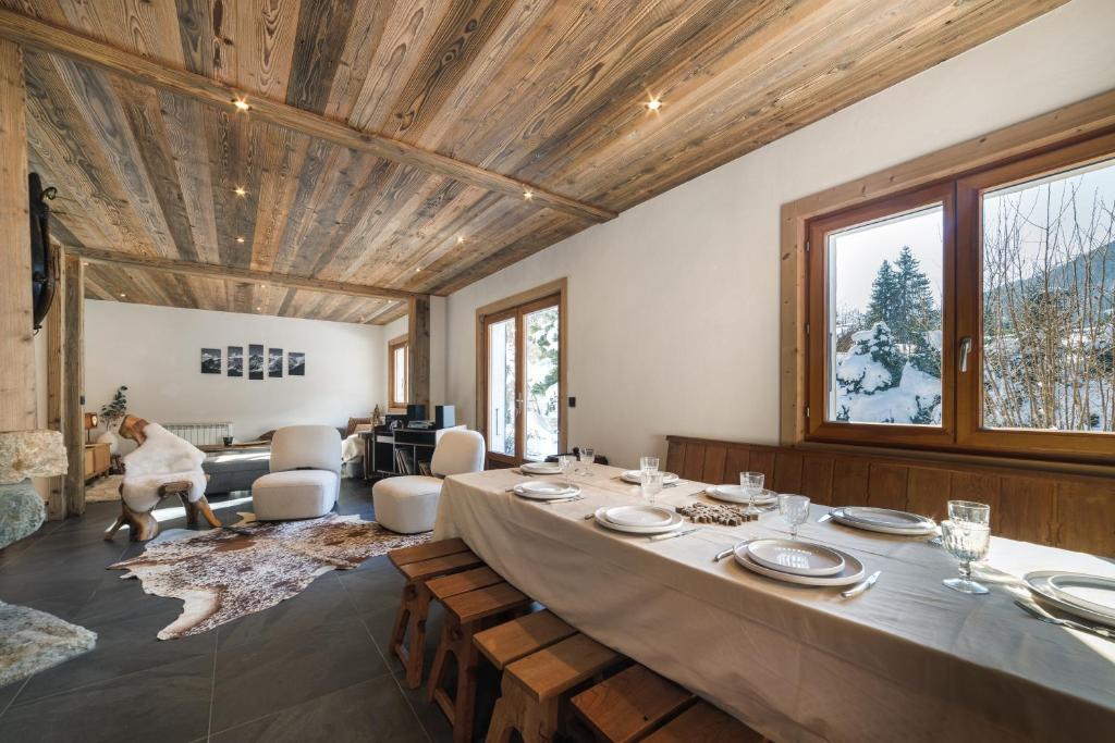 une grande salle à manger avec une table et des assiettes. dans l'établissement Chalet La Datcha, aux Contamines-Montjoie