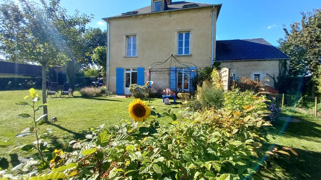 una vecchia casa con un giardino davanti di La Maison de 1868 a Vendeuvre