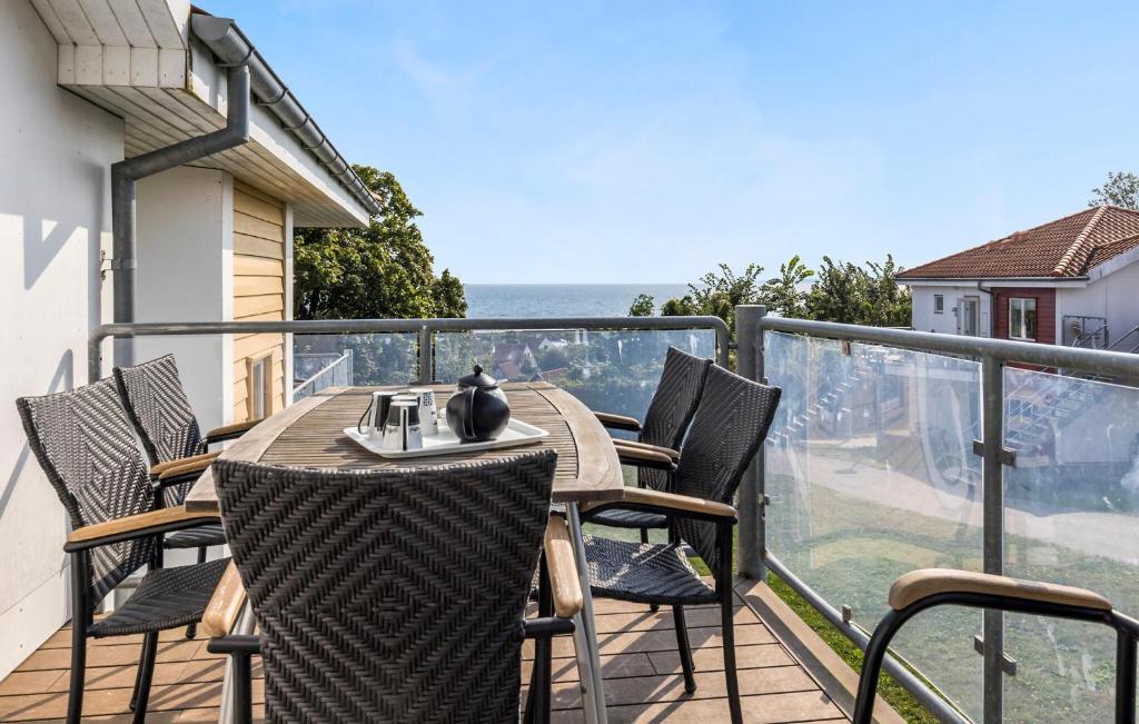 a table and chairs on a balcony with a view of the ocean at Gudhjem Søpark Lejl 34 in Gudhjem