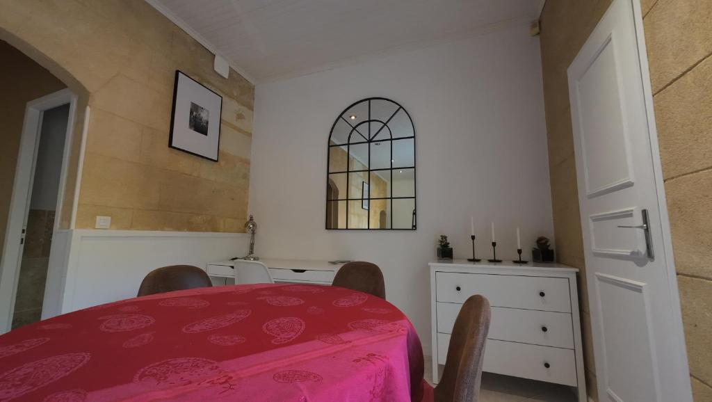 a dining room with a red table and a window at Escapade aux Chartrons in Bordeaux