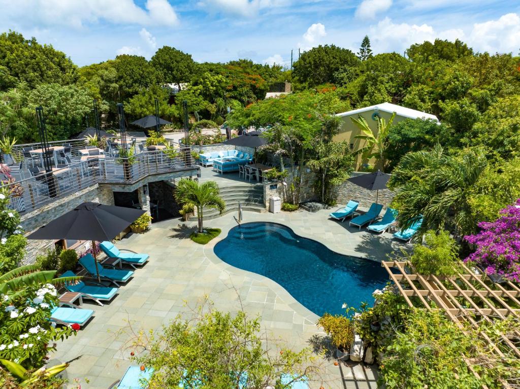Kokomo Botanical Resort - Caribbean Family Cottages في ترتل كوف: اطلالة علوية على مسبح مع كراسي للاستلقاء ومنتجع