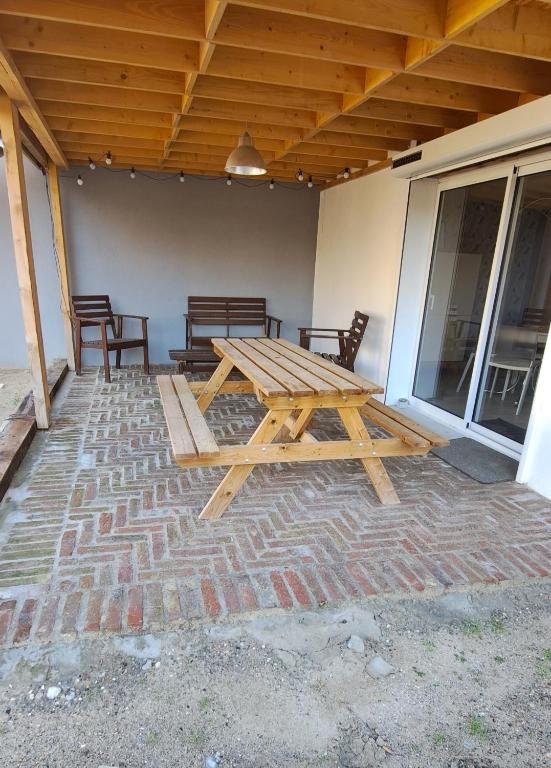 - une table de pique-nique en bois assise sur une terrasse dans l'établissement green, à Fort-Mahon-Plage